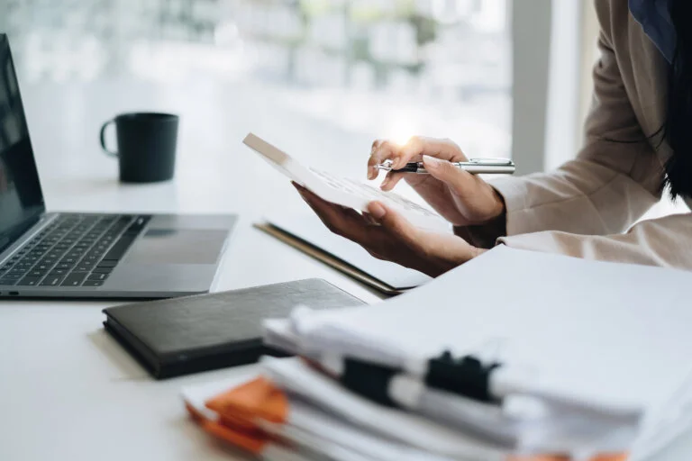 Asian Business Woman or Accountant do math and analyze with calculator and paperwork on desk, account, audit and saving concept administrative law proto law firm