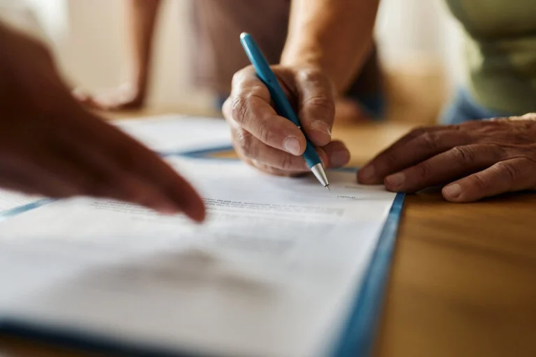 Close up of unrecognizable person signing a contract in the office. real estate faq proto law firm